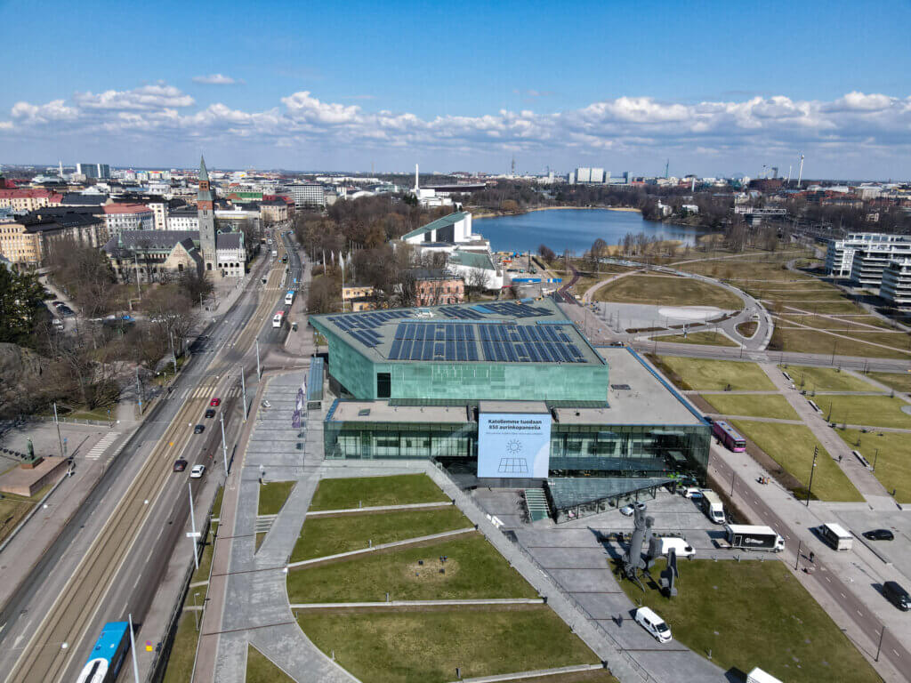 Kuva Musiikkitalosta ja sen ympäristöstä. Talon katolla on näkyy aurinkopaneelit.