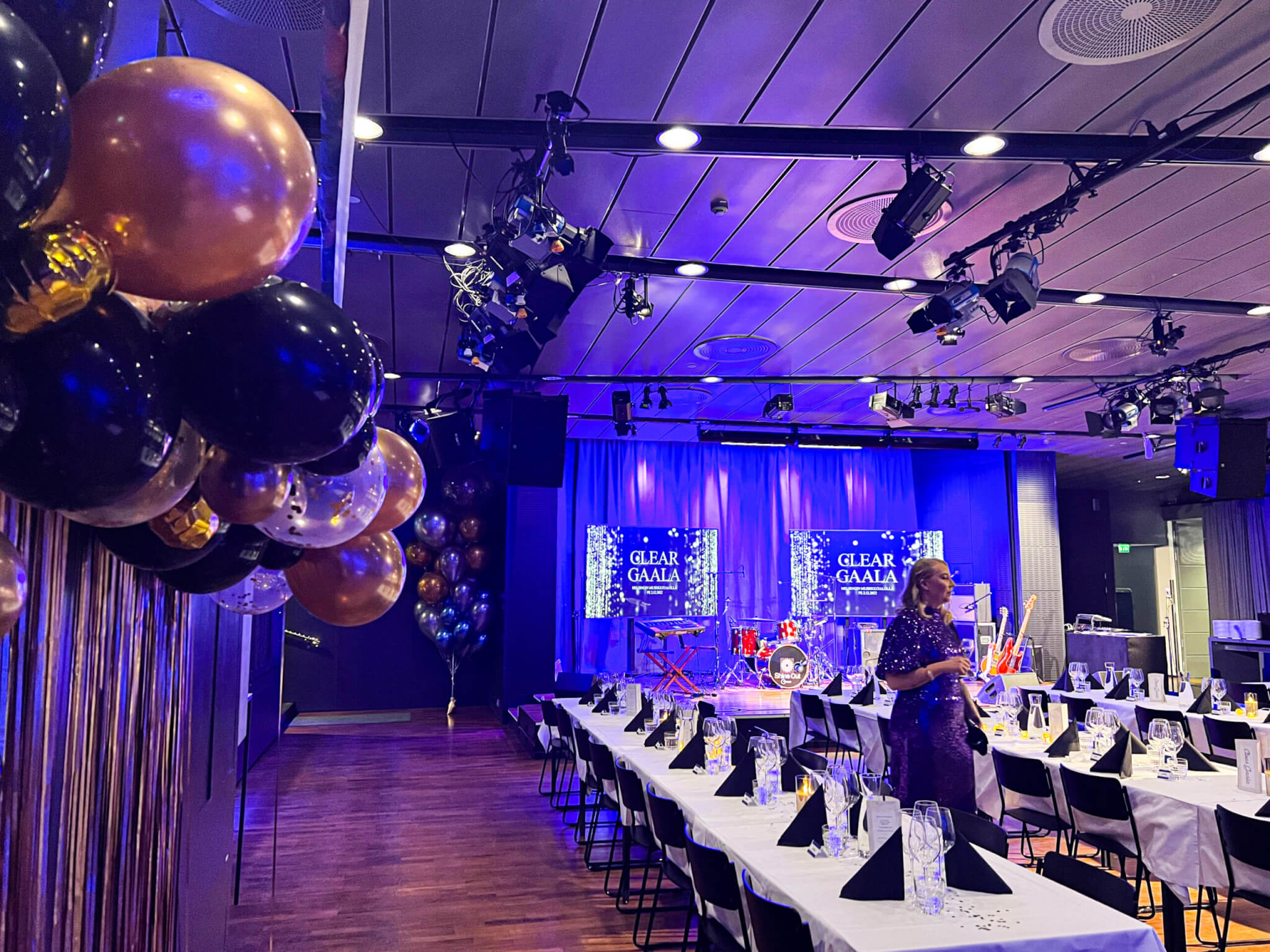 Musiikkitalon Ravintola-Klubissa on pitkät, liinoitetut pöydät juhlakattauksineen, servietteineen ja viinilaseineen. Tila on koristeltu ilmapalloilla ja valaistu sinisävyisillä valoilla.