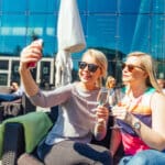 Kaksi naista ottamassa selfietä Musiikkitalon kesäisellä Terassilla